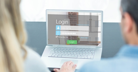 Digital composite of Man and woman looking at login screen on laptopの写真素材