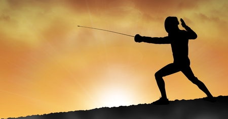 Digital composite of Silhouette man practicing fencing sport during sunsetの写真素材