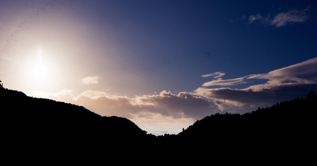 Digital composite of Silhouette mountain against sky during sunsetの写真素材