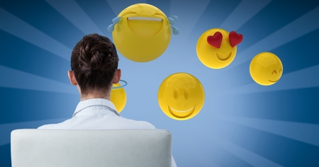 Digital composite of Digital composite image of businesswoman looking at emojisの写真素材