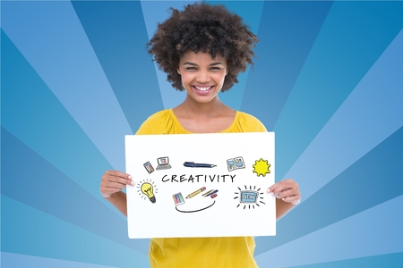 Digital composite of Portrait of woman holding billboard with creativity text against blue backgroundの写真素材