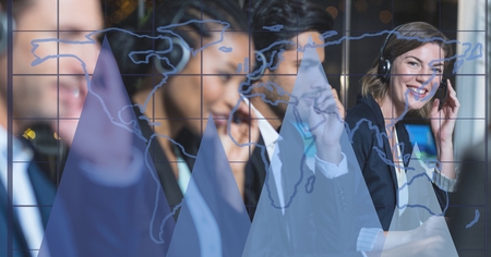 Digital composite of Digital composite image of graphs and grid with business people working in...