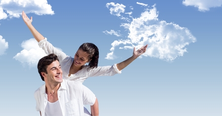 Digital composite of Happy man giving piggyback ride to woman against skyの写真素材
