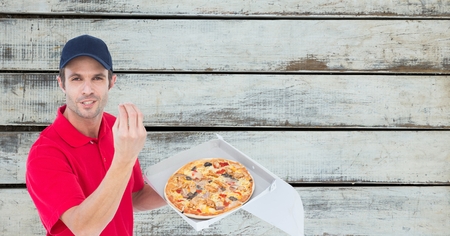Digital composite of Delivery man gesturing while holding fresh pizzaの写真素材