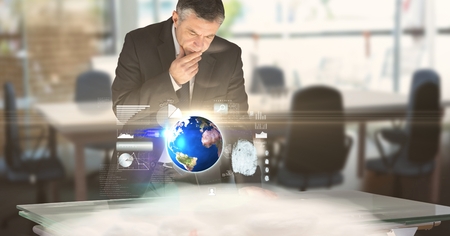 Digital composite of Digital composite image of businessman working at futuristic deskの写真素材