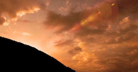 Digital composite of Silhouette mountain against cloudy sky during sunset