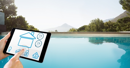 Digital composite of Hands using smart home app on tablet PC by pool