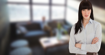 Digital composite of Businesswoman with arms crossed standing in officeの写真素材