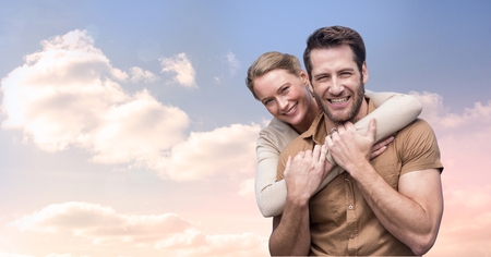 Digital composite of Portrait of smiling couple embracing against cloudy skyの写真素材
