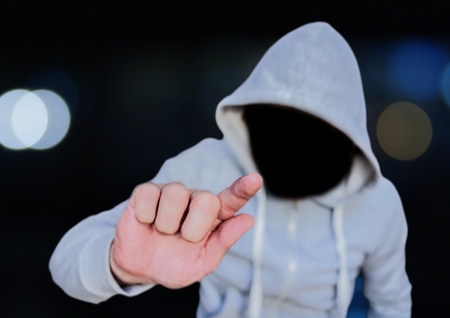 Digital composite of Anonymous Criminal Man in hood in front of city lights