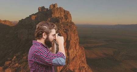 Digital composite of mountain travel, man taking a photo in the montainの写真素材