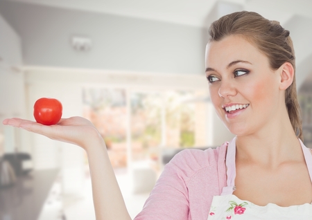 Digital composite of Cook woman in the kitchen of the house looking the tomatoの写真素材