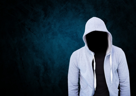 Digital composite of Anonymous Criminal Man in hood in front of blue backgroundの写真素材