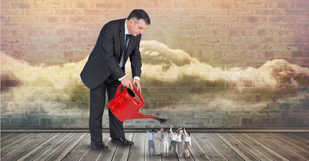 Digital composite of Digital composite image of businessman pouring water on employees from watering canの写真素材