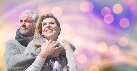 Digital composite of Happy couple in warm clothing against bokeh