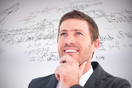 Businessman smiling and thinking against grey backgroundの写真素材
