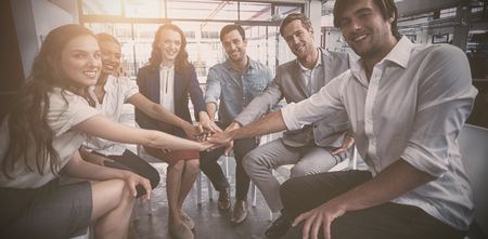Portrait of business people forming hand stack in officeの写真素材