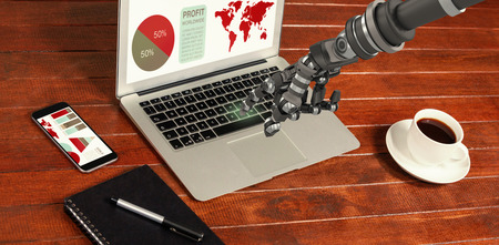 Back robot arm pointing at something against high angle view of laptop with notepad and cup of coffeeの写真素材