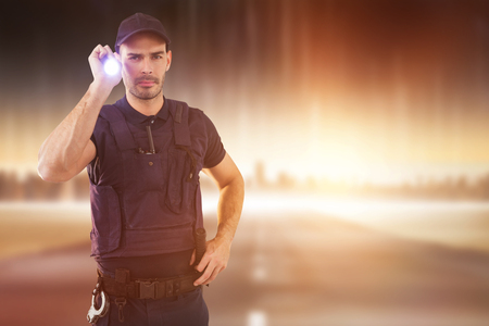 Portrait of security officer holding lit torch against city on the horizon