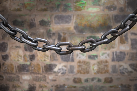 3d image of metallic chain against full frame shot of stone wall