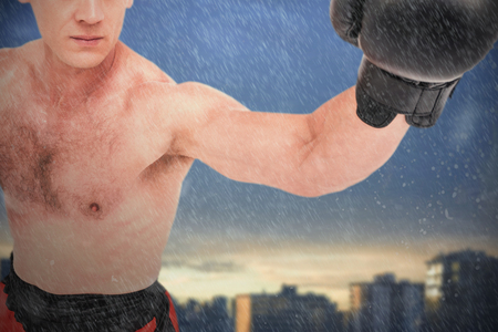 Boxer performing boxing stance against city against cloudy sky during sunsetの写真素材