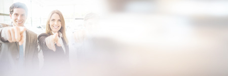 Portrait of business team pointing together while standing at showroomの写真素材