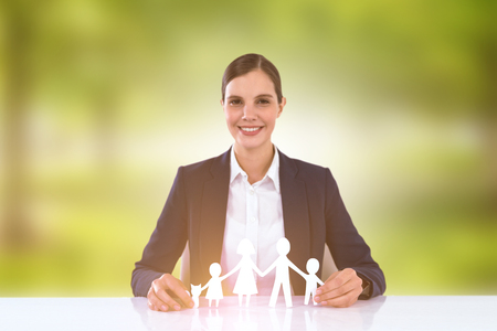 family in white paper with a woman in the background against trees in grassy landscapeの写真素材