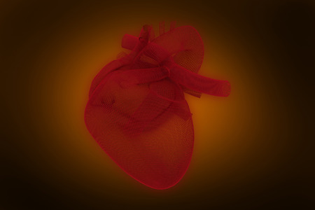 Digitally generated image of 3d human heart  against orange background with vignette