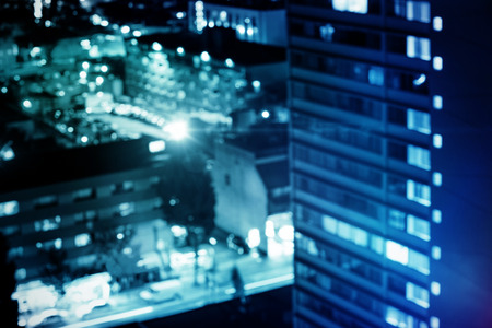 flared figure against illuminated buildings in city at nightの写真素材