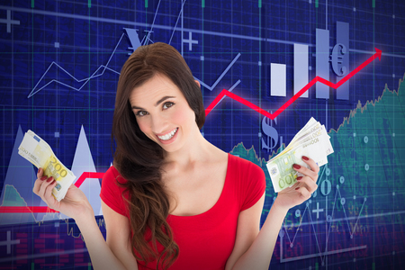 Cheerful brunette holding her cash money  against red arrowの写真素材