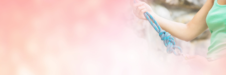 Female rock climber adjusting harness by rock faceの写真素材