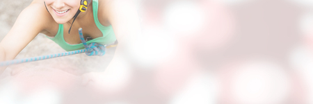 Happy girl climbing rock face wearing red helmetの写真素材