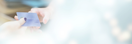 Cropped image of hand handing over credit card at counter of shopの写真素材