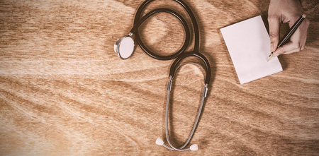 Cropped hand of doctor writing prescription on paperの写真素材