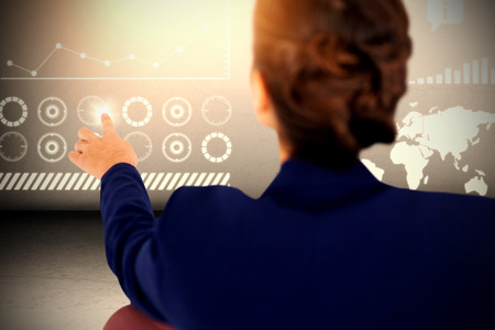 Rear view of businesswoman working on white background against grey roomの写真素材