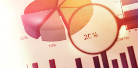 flared figure against close up of magnifying glass on graph chartの写真素材