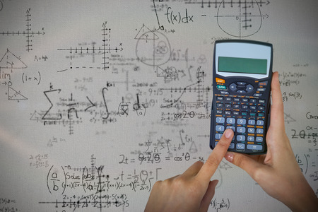 Hands of businesswoman using calculator against quadratic equations with solutionの写真素材