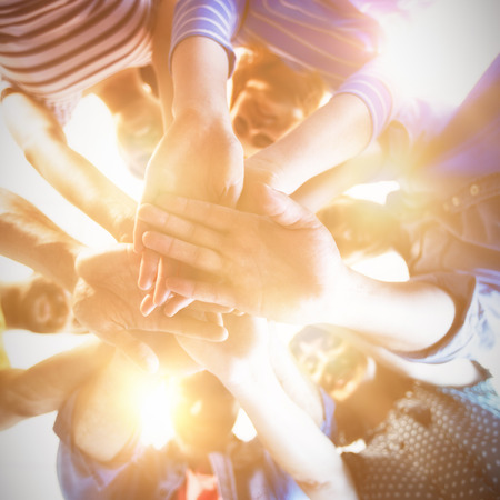 Creative business team stacking hands together in officeの写真素材