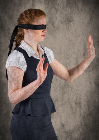 Digital composite of Business woman blindfolded with grunge overlay against brown backgroundの写真素材