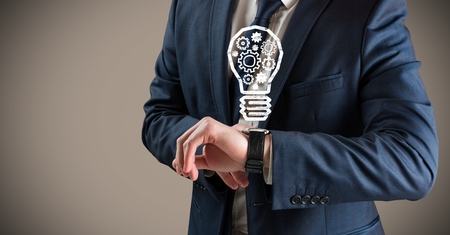 Digital composite of Business man mid section with lightbulb doodles over watch against brown backgroundの写真素材