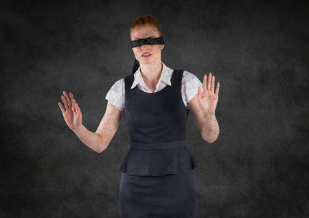 Digital composite of Business woman blindfolded with grunge overlay against grey wallの写真素材