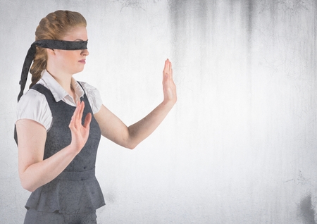 Digital composite of Business woman blindfolded with grunge overlay against white wallの写真素材
