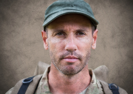 Digital composite of Soldier face with grunge overlay against brown backgroundの写真素材