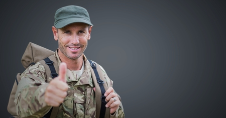 Digital composite of Soldier thumbs up against grey backgroundの写真素材