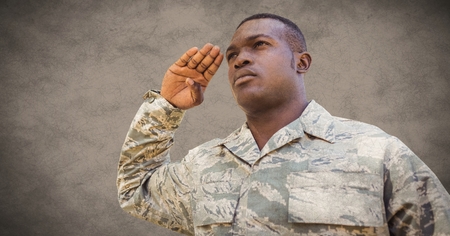 Digital composite of Soldier saluting against brown background with grunge overlayの写真素材