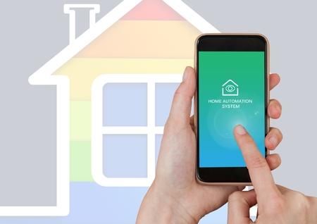Digital composite of Hand touching mobile ohone with Home automation system App Interface