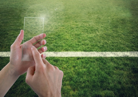 Digital composite of Hand touching glass screen on sports pitchの写真素材