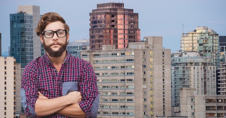 Digital composite of Confident male hipster with arms crossed against buildingsの写真素材