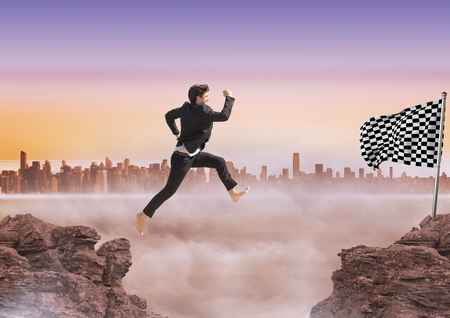 Digital composite of Businessman jumping in the rocks to catch the checker flagの写真素材