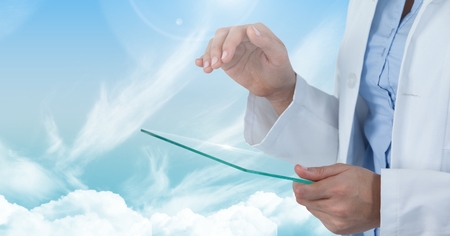 Digital composite of Doctor touching glass with cloudy skyの写真素材